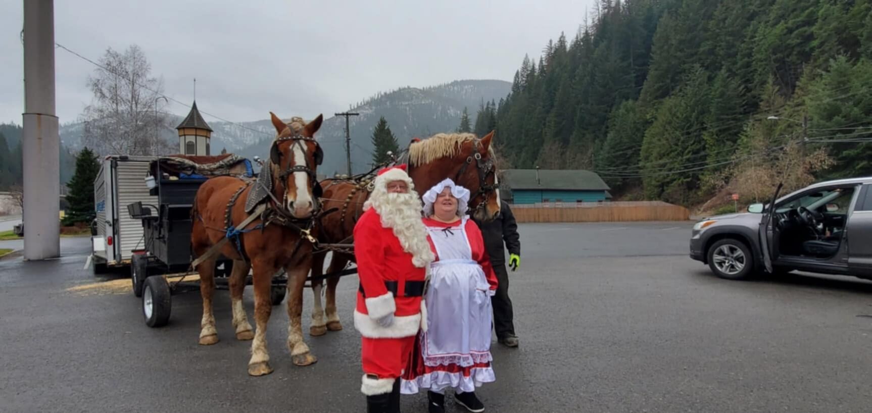 Mr. and Mrs. Claus with horses outside