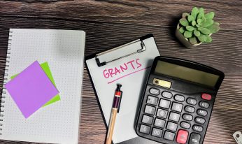 Concept of Grants write on paperwork isolated on wooden background.