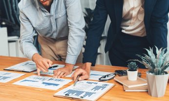 Analyst team in office analyzing financial data analysis for marketing strategy in workspace, pile of BI dashboard paper format with graph and chart to optimize performance and risk management. Entity
