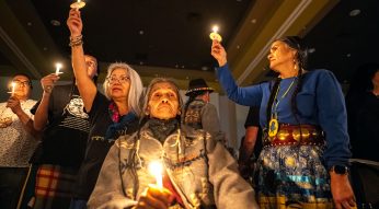 During the The Kalispel tribe 14th annual Celebrating Salish Conference’s Trailblazer awards, left to right, Trish Manuel, Larry Kenoras and Shelly Boyd join hundreds of attendees holding candles in the Pend Orielle Pavilion at North Quest Casino, Thursday, March 8, 2024. The sharing of candlelight emanating out from an inner circle, symbolizes lighting a spark for the future.
