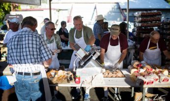 Cooks prepare barbeque meal outdoors