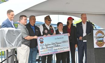 An image of the grant given to Operation Fly Together as Innovia presents a $5,000 check.